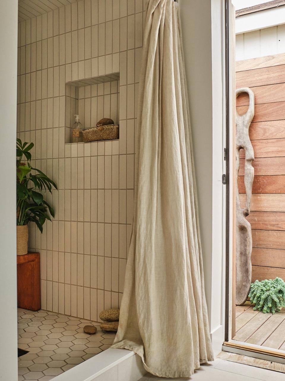 Outdoor shower peeking out from indoor bathroom