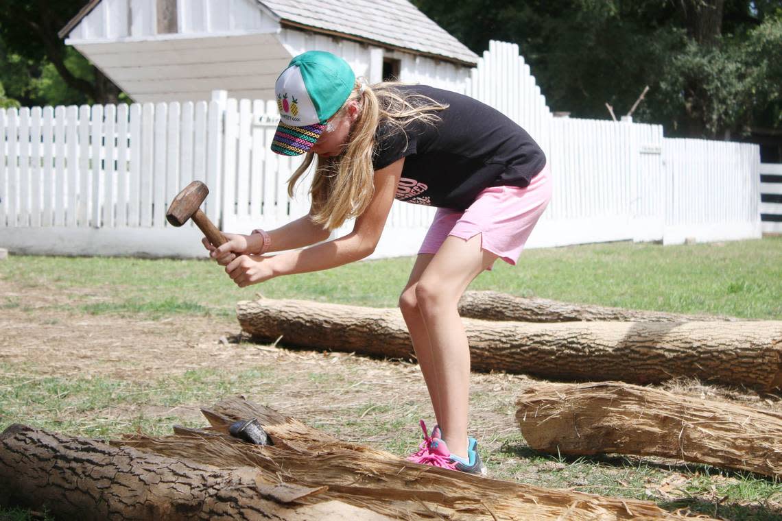 Overland Park resident Rachel Holder, 10, uses a mallet to split fence rails from logs at the Mahaffie Stagecoach Stop and Farm’s fall homeschool event Sept. 1.