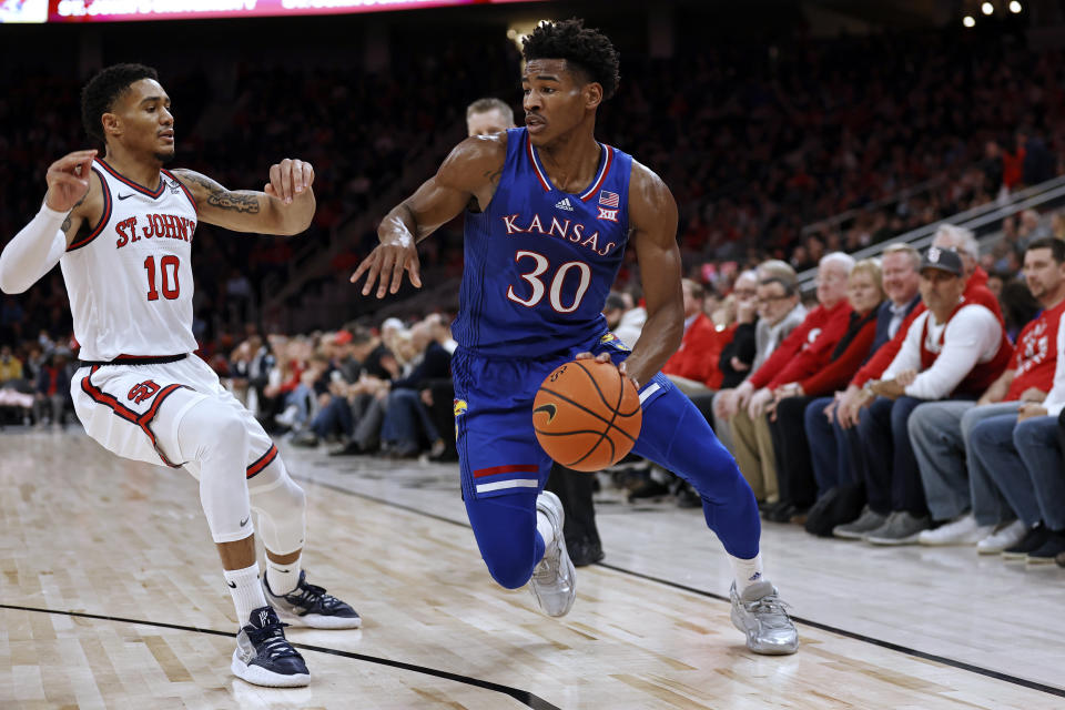 Kansas guard Ochai Agbaji (30) drives past St. John's guard Tareq Coburn during the first half of an NCAA college basketball game Friday, Dec. 3, 2021, in Elmont, N.Y. (AP Photo/Adam Hunger)