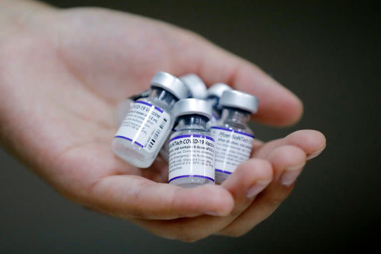 A health worker show vials of the Pfizer-BioNTech vaccine against the coronavirus disease COVID-19 at a vaccination centre in Santiago, on 10 January 2022. - Chile started administering today a fourth COVID-19 vaccine dose to people over the age of 12 with weakened immune systems. (Photo by Javier TORRES / AFP)