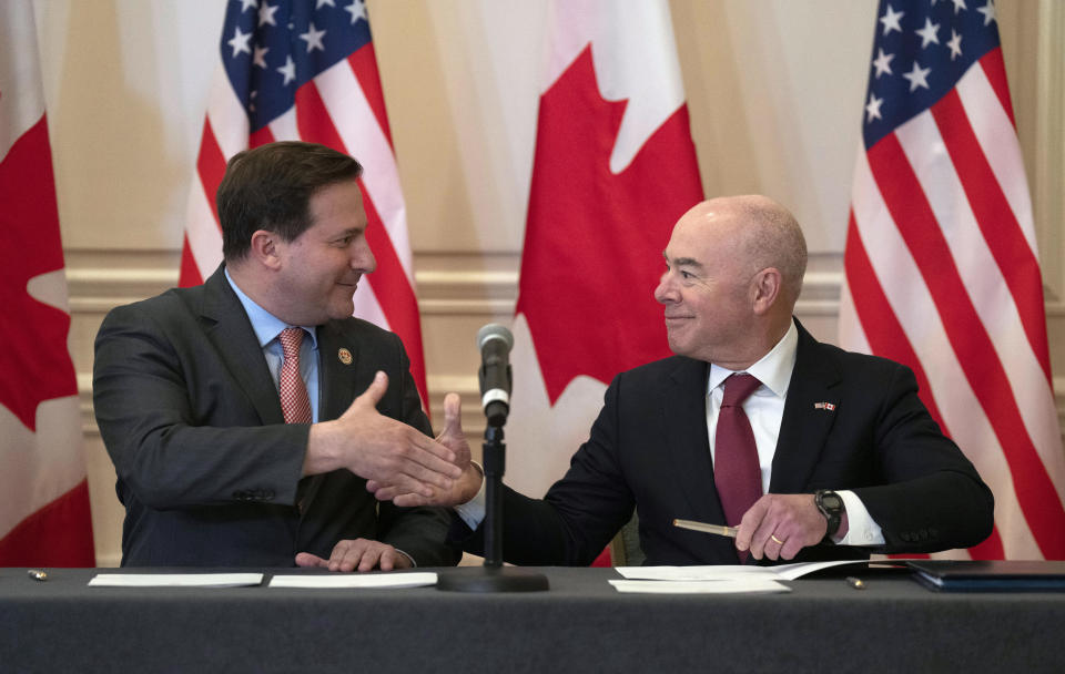 Public Safety Minister Marco Mendicino and U.S. Secretary of Homeland Security Alejandro Mayorkas shake hands after signing an agreement following the conclusion of the 2023 Canada-United States Cross-Border Crime Forum, Friday, April 28, 2023 in Ottawa, in Ontario. (Adrian Wyld/The Canadian Press via AP)