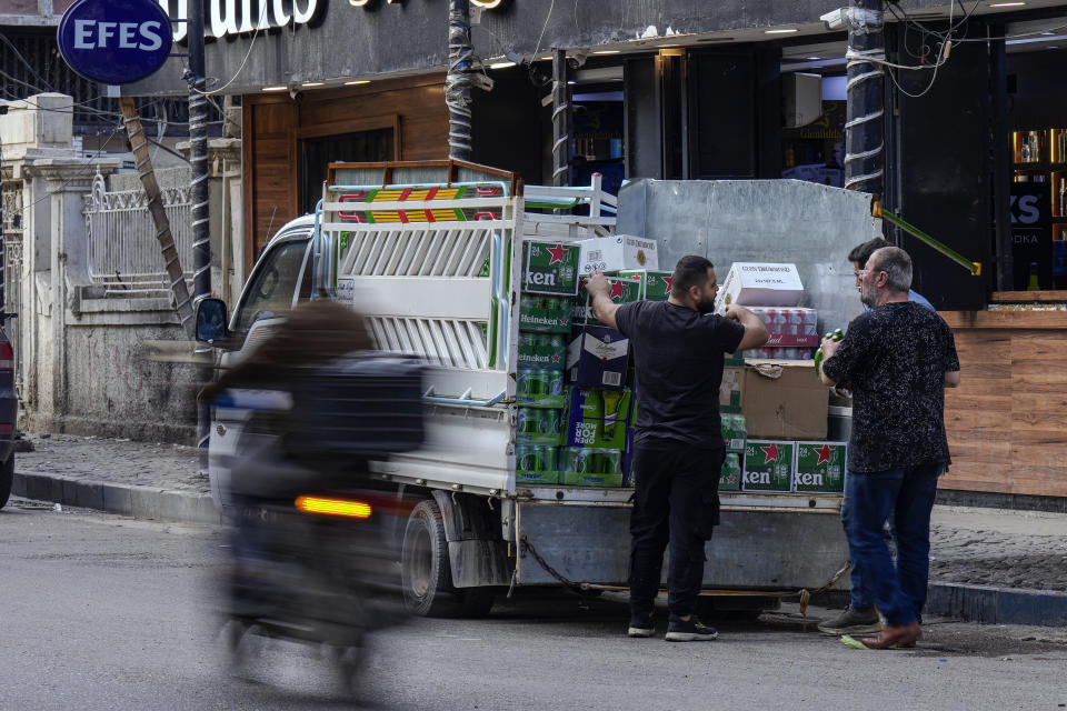 Men deliver beer to a liquor store in Baghdad, Iraq, Thursday, March 9, 2023. The Iraqi government started enforcing a 2016 ban on alcoholic beverages this month, although many liquor shops remained open in Baghdad. (AP Photo/Hadi Mizban)