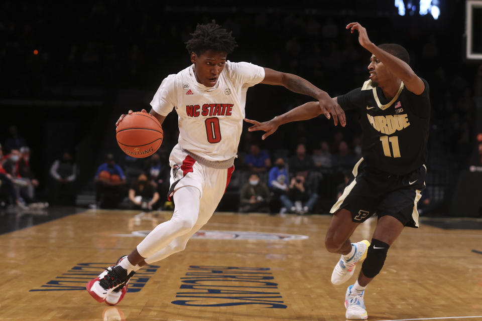 North Carolina State's Terquavion Smith (0) drives against Purdue's Isaiah Thompson (11) during the first half of an NCAA college basketball game Sunday, Dec. 12, 2021, in New York. (AP Photo/Jason DeCrow)