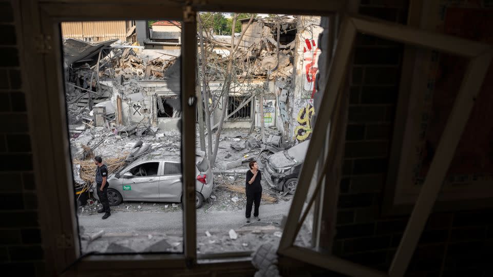 Israelis inspect the rubble of a building a day after it was hit by a rocket fired from the Gaza Strip, in Tel Aviv, Israel, on Sunday.  - Oded Balilty/AP