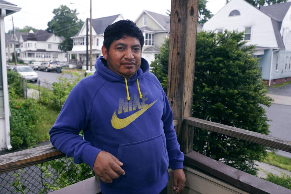 Lucio Perez poses on the porch of his home, where he has lived with his family since March, Thursday, July 8, 2021, in Springfield, Mass. Just a few months ago, Perez moved out of a western Massachusetts church he'd lived in for more than three years to avoid deportation. Immigration authorities in March granted the 37-year-old Guatemalan national a temporary stay in his deportation while he argued to have his immigration case reconsidered. (AP Photo/Charles Krupa)