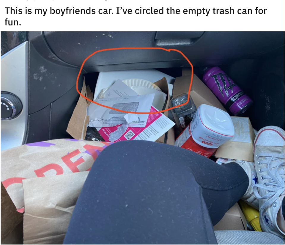 Garbage all over the floor in front of a seat in the car