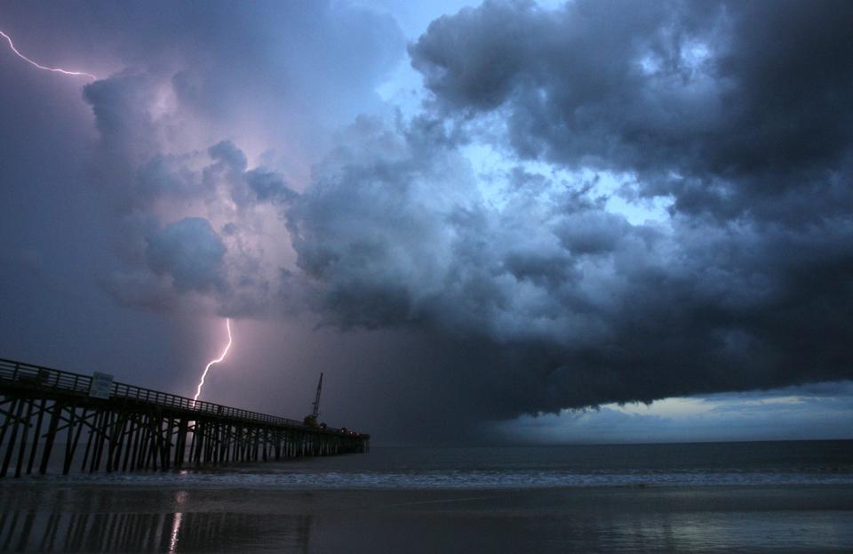 A vein of lightning strikes beyond the Flagler Pier, in Flagler Beach, Fla., during a summer storm.