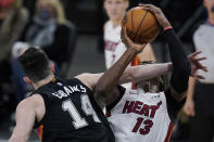 Miami Heat center Bam Adebayo (13) is fouled by San Antonio Spurs forward Drew Eubanks (14) as he drives to the basket during the second half of an NBA basketball game in San Antonio, Wednesday, April 21, 2021. (AP Photo/Eric Gay)