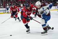 CORRECTS AVALANCHE PLAYER TO NATHAN MACKINNON, INSTEAD OF LOGAN O'CONNOR - Washington Capitals defenseman Martin Fehervary (42) defends against Colorado Avalanche right wing Nathan MacKinnon (29) during the second period of an NHL hockey game, Tuesday, Oct. 19, 2021, in Washington. (AP Photo/Alex Brandon)