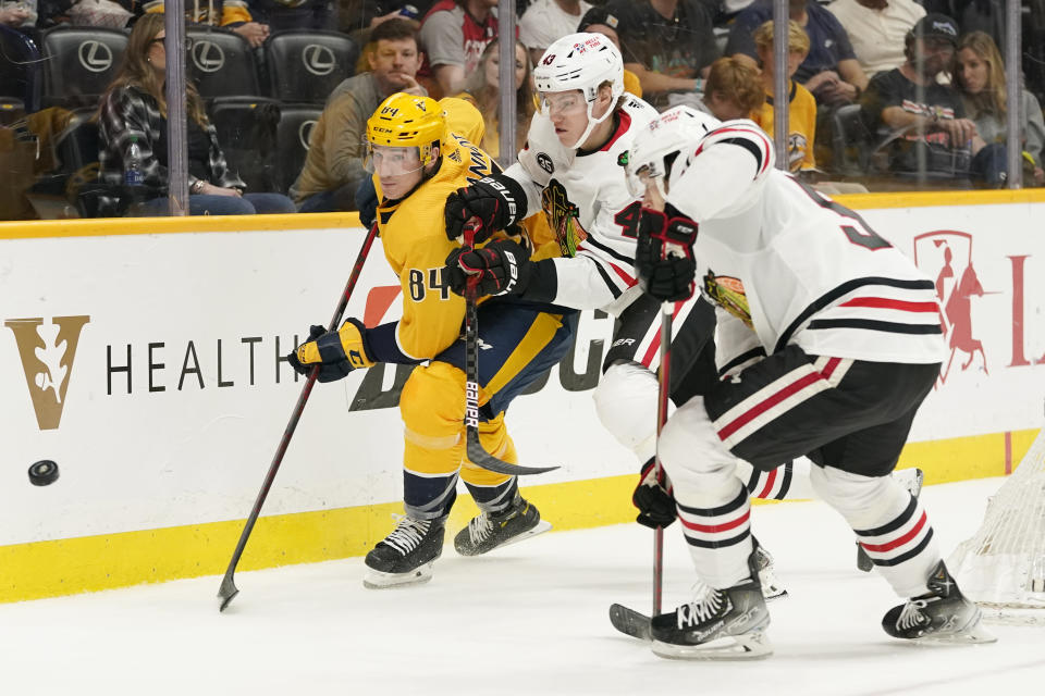 Nashville Predators' Tanner Jeannot (84) chase the puck with Chicago Blackhawks' Alex Vlasic (43) in the second period of an NHL hockey game Saturday, April 16, 2022, in Nashville, Tenn. (AP Photo/Mark Humphrey)