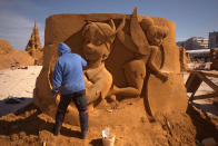 <p>A sand carver works on a sculpture during the Sand Sculpture Festival “Disney Sand Magic” in Ostend, Belgium. (Photo courtesy of Disneyland Paris) </p>