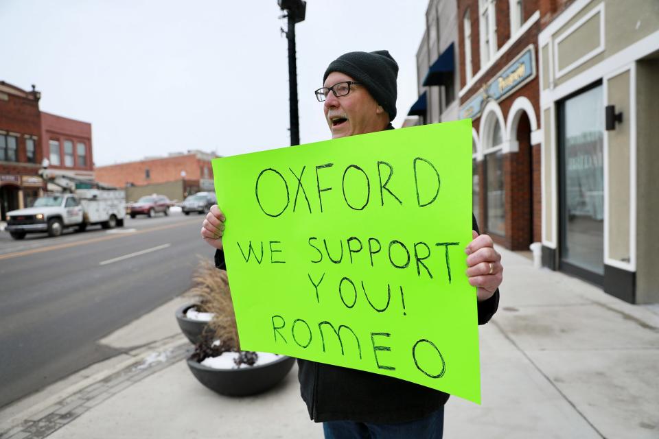 Larry Delcourt, 63, of Romeo, holds a sign up while standing in downtown Oxford, Mich., to show his support for the community after the school shooting at Oxford High School, on Dec. 1, 2021. Delcourt says his community is also small and felt it on his heart to make a sign and come to Oxford.