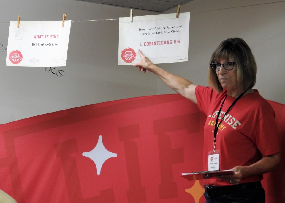 Cindy Massie points to the Bible passage for the day students learn as part of the Lifewise Academy release time program at Conesville United Methodist Church, across from Conesville Elementary School