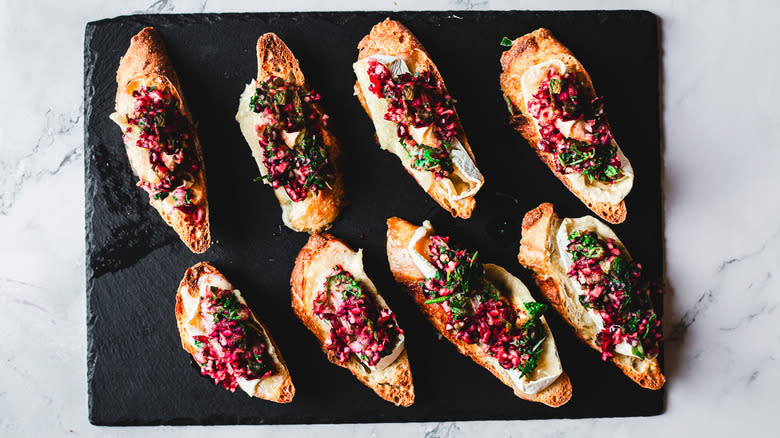 Crostini with cranberry salsa on black cutting board