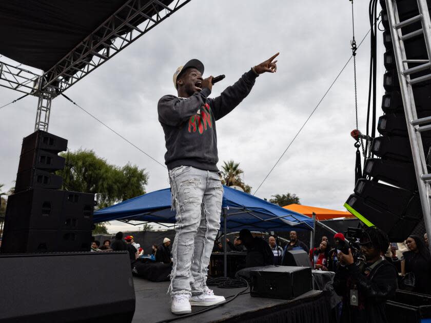 Ray Vaughn addresses the crowd at Top Dawg Entertainment's annual toy drive and concert at the Nickerson Gardens housing project Tuesday in Los Angeles.