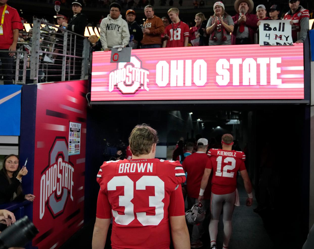 Dec 29, 2023; Arlington, Texas, USA; Ohio State Buckeyes quarterback Devin Brown (33) and Ohio State Buckeyes quarterback Lincoln Kienholz (12) walk off the field after losing 14-3 to Missouri Tigers in the Goodyear Cotton Bowl Classic at AT&T Stadium.