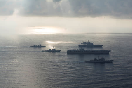 FILE PHOTO: The Ronald Reagan Strike Group ship's the aircraft carrier USS Ronald Reagan (CVN 76), the guided-missile cruiser USS Antietam (CG 54) and the guided-missile destroyer USS Milius (DDG 69) conduct a photo exercise with the Japan Maritime Self-Defense Force ship's the helicopter destroyer JS Kaga (DDH 184), the destroyer JS Inazuma (DD 105) and the destroyer JS Suzutsuki (DD 117) in the South China Sea August 31, 2018. Mass Communication Specialist 3rd Class Erwin Jacob V. Miciano/U.S. Navy/Handout via REUTERS