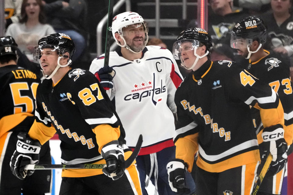 Washington Capitals' Alex Ovechkin, center, celebrates after assisting on a goal by teammate Hendrix Lapierre (not shown) as Pittsburgh Penguins' Sidney Crosby (87) and Valtteri Puustinen skate back to their bench during the second period of an NHL hockey game in Pittsburgh, Thursday, March 7, 2024. (AP Photo/Gene J. Puskar)