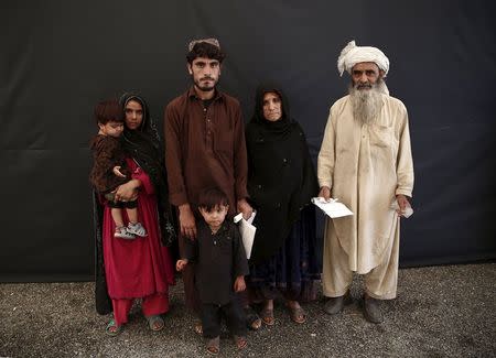 Rahim Khan (R) poses for a picture with his family after they arrive at a United Nations High Commissioner for Refugees (UNHCR) registration centre in Kabul, Afghanistan August 26, 2015. REUTERS/Ahmad Masood
