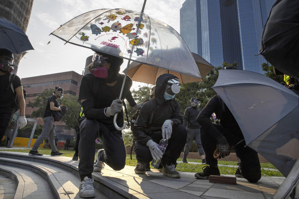 Protestors hold umbrellas as they wait for a possible volley of tear gas at the Hong Kong Polytechnic University campus in Hong Kong, Thursday, Nov. 14, 2019. University students from mainland China and Taiwan are fleeing Hong Kong, while those from three Scandinavian countries have been moved or urged to leave as college campuses become the latest battleground in the city's 5-month-long anti-government unrest. (AP Photo/Ng Han Guan)