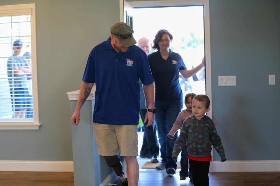 Marine LCpl. Bryan Chambers and his family take their first steps into the new home they received from the non-profit organization, Homes for Our Troops, on Saturday, Oct. 1, 2022, in Attica, Ind.