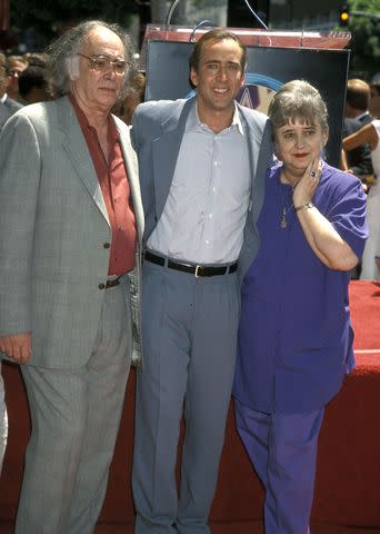 <p>Ron Galella, Ltd./Ron Galella Collection via Getty</p> Nicolas Cage (center) and his father August Coppola and mother Joy Vogelsang attend his Hollywood Walk of Fame ceremony in 1998.