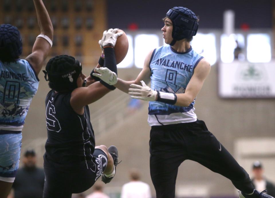 Andrew Greve (8), right, reaches for the ball during a 7-on-7 football tournament Saturday at the UNI-Dome in Cedar Falls.