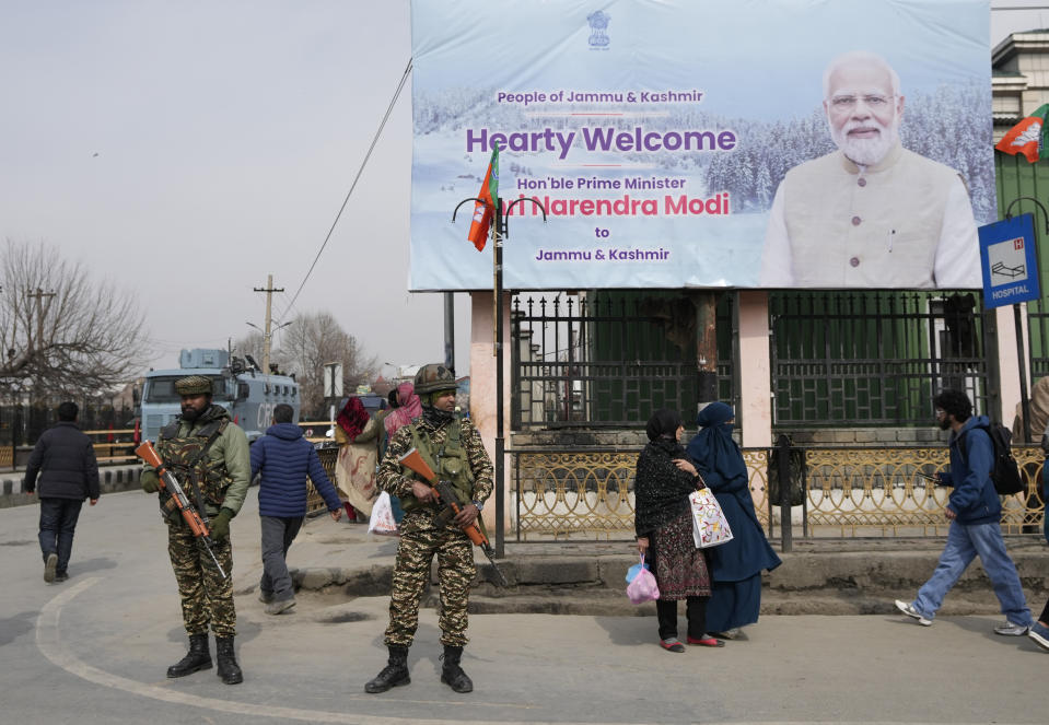 Paramilitary soldiers guard near a billboard ahead of Indian Prime Minister Narendra Modi's visit to Srinagar, Indian controlled Kashmir, Wednesday, March 6, 2024. Modi is scheduled to address a public rally in Srinagar on Thursday. (AP Photo/Mukhtar Khan)