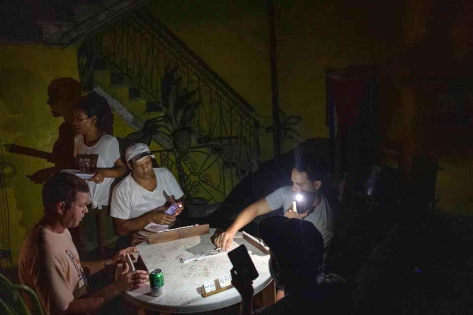 Un grupo de cubanos juega al dominó con una linterna durante un apagón en La Habana, Cuba, el miércoles 28 de septiembre de 2022. Cuba permaneció a oscuras la madrugada del miércoles después de que el huracán Ian destruyó su red eléctrica. (Foto AP/Ramón Espinosa)