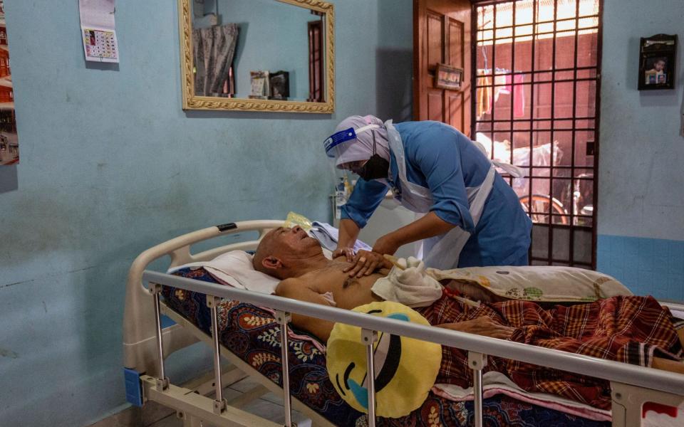 A bed-ridden patient receives a Covid-19 vaccine in Kuala Langat, Malaysia on 17 July 2021 - Ahmad Yusni/Shutterstock