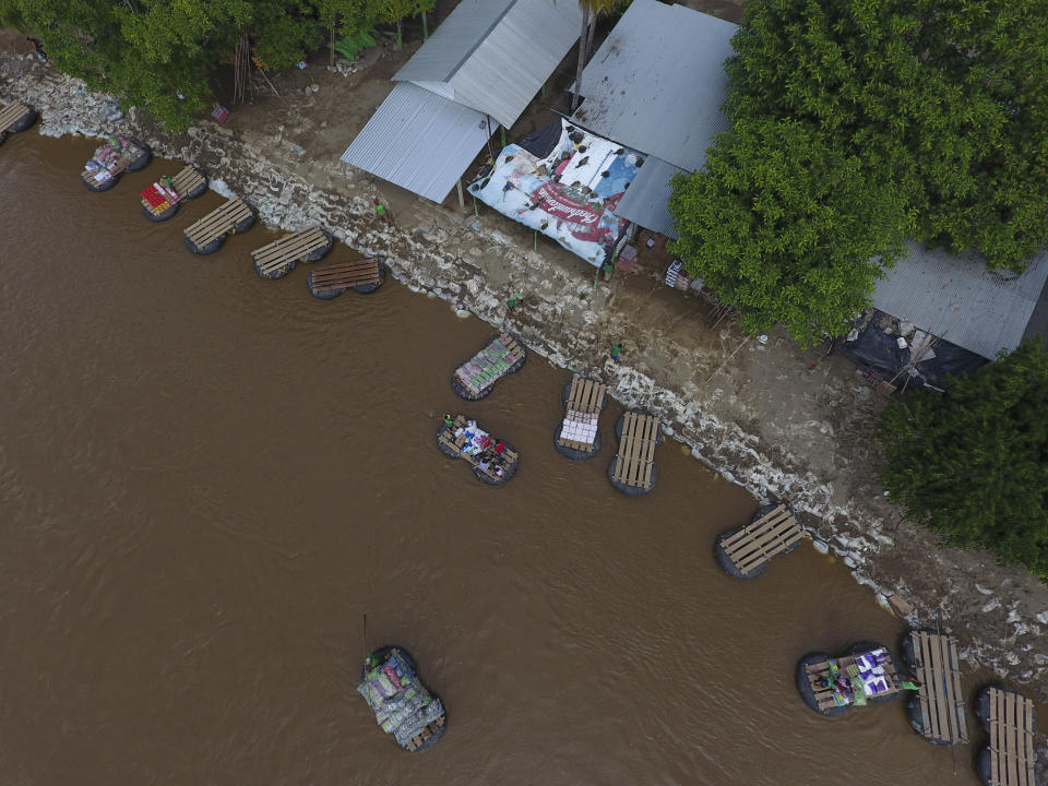 Inner tube and plank rafts ferry passengers and merchandise freely across the Suchiate River between Ciudad Hidalgo, Mexico, and Guatemala (not pictured), Thursday, June 13, 2019. Mexican officials said earlier in the week they were beginning deployment of the country's new National Guard for immigration enforcement, but on Thursday, it was still daily life as usual along the Suchiate, with people and goods moving back and forth in a relaxed flow of cross-border traffic. (AP Photo/Rebecca Blackwell)