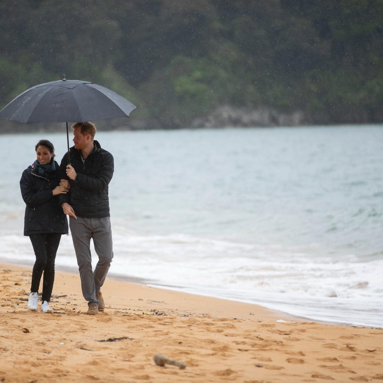  Prince Harry and Meghan Markle walking on the beach 
