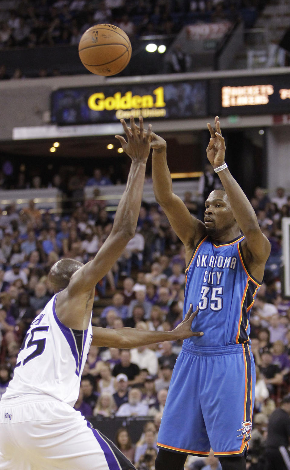 Oklahoma City Thunder forward Kevin Durant, right, passes over Sacramento Kings forward Travis Outlaw during the first quarter of an NBA basketball game, Tuesday, April 8, 2014, in Sacramento, Calif. (AP Photo/Rich Pedroncelli)