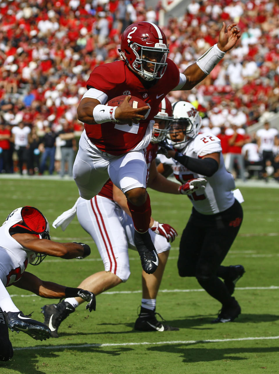 Alabama quarterback Jalen Hurts (2) hurdles Arkansas State defensive back Jeremy Smith (24) as he carries the ball during the first half of an NCAA college football game, Saturday, Sept. 8, 2018, in Tuscaloosa, Ala. (AP Photo/Butch Dill)