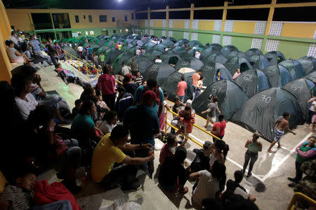 People rest at the municipal coliseum after the Colombian government ordered the evacuation of residents living along the Cauca river, as construction problems at a hydroelectric dam prompted fears of massive flooding, in Valdivia, Colombia May 17, 2018. REUTERS/Fredy Builes