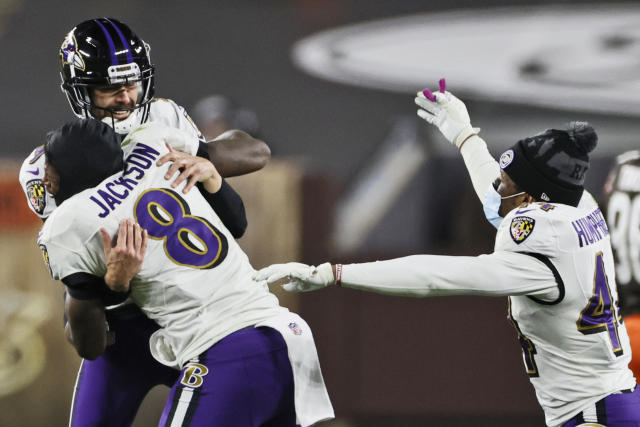 Lamar Jackson of the Baltimore Ravens wipes his face during a time