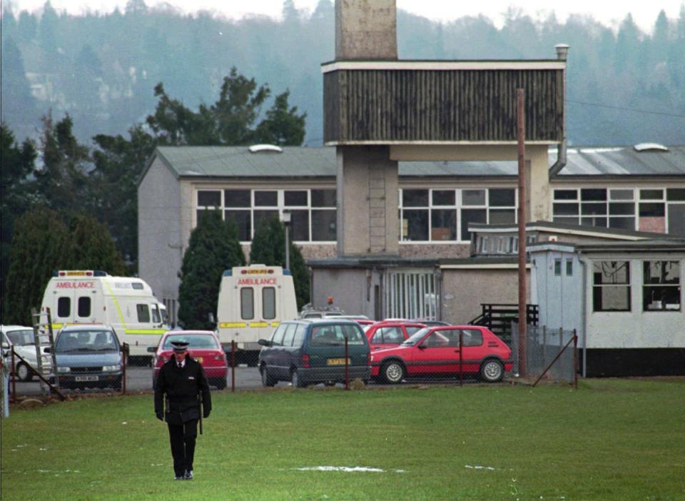 FILE - A police officer walks on the grounds of the Dunblane Primary School in Dunblane, Scotland, where a lone gunman burst into the school's gymnasium killing 16 children, one teacher, and himself Wednesday, March 13, 1996. The 1996 massacre in Dunblane led to a ban on owning handguns in the U.K. While Britain is not immune to gun violence, there have been no school shootings in the quarter century since. (AP Photo/Lynne Sladky, File)