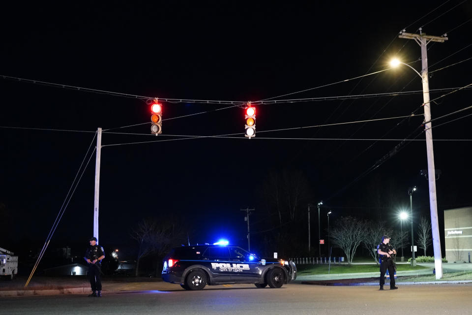 Police officers guard the road to a recycling facility where the body of Robert Card, the suspect in this week's mass shootings, was found, Friday, Oct. 27, 2023, in Lisbon, Maine. Card was wanted for the shooting deaths of 18 people at a bowling alley and a bar in Lewiston, Maine on Wednesday. (AP Photo/Robert F. Bukaty)