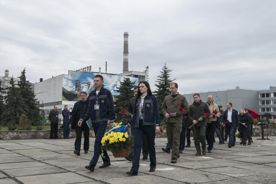 Chernobyl's nuclear power plant workers lay flowers at a monument to the victims of the Chernobyl tragedy during a memorial ceremony in Chernobyl, Ukraine, Wednesday, April 26, 2023. Ukrainian President Volodymyr Zelenskyy on Wednesday used the 37th anniversary of the world’s worst nuclear disaster to repeat his warnings about the potential threat of a new atomic catastrophe in Ukraine amid his country's war with Russia. (AP Photo/Wladyslaw Musiienko)