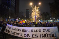 Demonstrators march holding a banner reading "you have taught us that being peaceful is useless" during a protest condemning the arrest of rap singer Pablo Hasel in Barcelona, Spain, Sunday, Feb. 21, 2021. The imprisonment of Pablo Hasel for inciting terrorism and refusing to pay a fine after having insulted the country's monarch has triggered a social debate and street protests. (AP Photo/Emilio Morenatti)