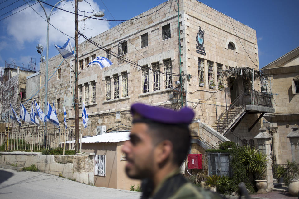 In this Wednesday, March 6, 2019 photo, an Israeli soldier stands guard in the Israeli controlled part of the West Bank city of Hebron. The Falic family, owners of the ubiquitous chain of Duty Free America shops, fund a generous, and sometimes controversial, philanthropic empire in Israel that stretches deep into the West Bank. The family supports many mainstream causes as well as far right causes considered extreme even in Israel. (AP Photo/Ariel Schalit)