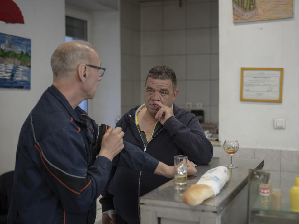 Workers have a drink at a bar in the Malpasse neighbourhood in Marseille, southern France, Tuesday, April 16, 2024. (AP Photo/Daniel Cole)