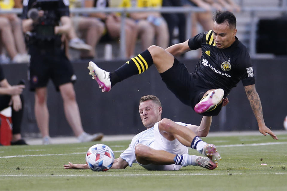 Chicago Fire's Fabian Herbers, bottom, slides under Columbus Crew's Lucas Zelarayan during the first half of an MLS soccer match Saturday, June 19, 2021, in Columbus, Ohio. (AP Photo/Jay LaPrete)