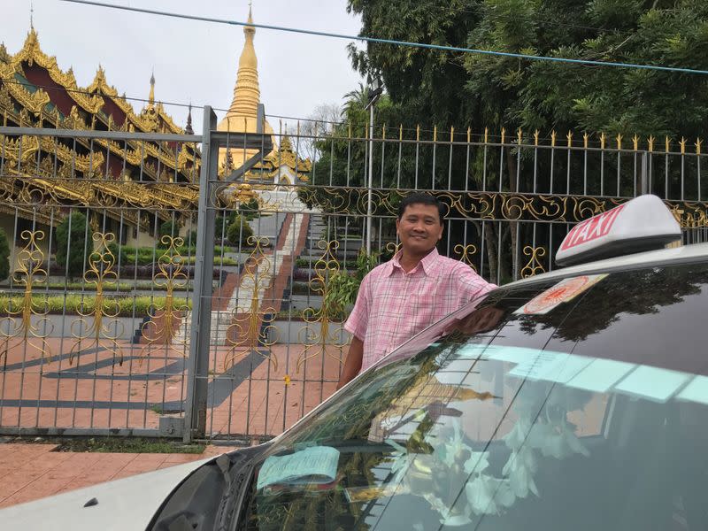 Taxi driver Ko Naing poses in front of Shwedagon Pagoda in Yangon