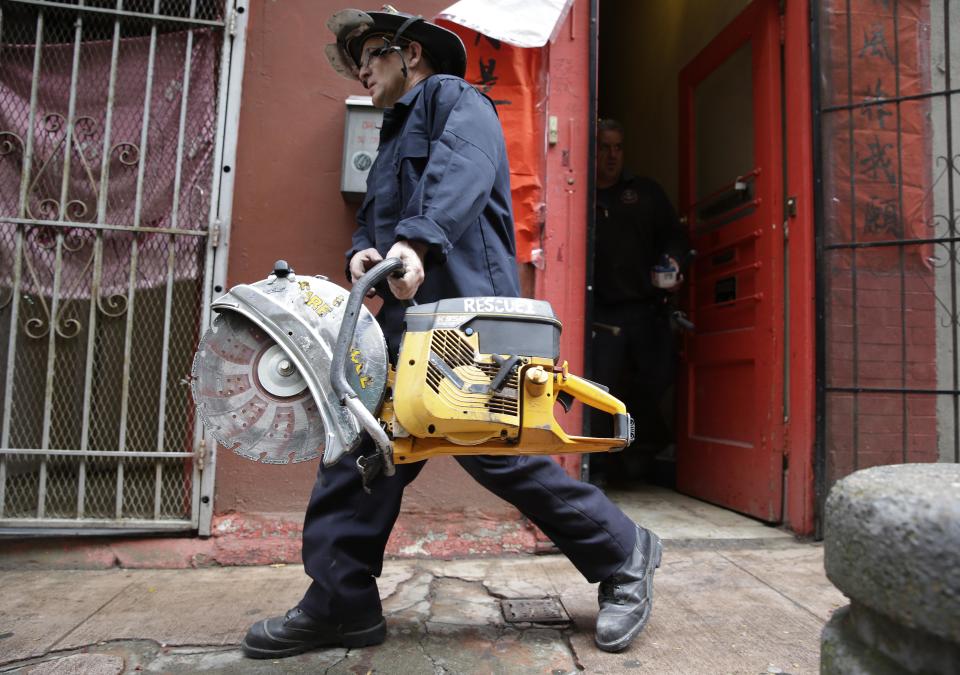 A San Francisco fireman carries away a saw after assisting FBI agents during a search of a Chinatown fraternal organization Wednesday, March 26, 2014, in San Francisco. A California state senator was arrested Wednesday during a series of raids by the FBI in Sacramento and the San Francisco Bay Area, authorities said. An FBI spokesman confirmed the arrest of State Sen. Leland Yee, but declined to discuss the charges, citing an ongoing investigation. (AP Photo/Eric Risberg)