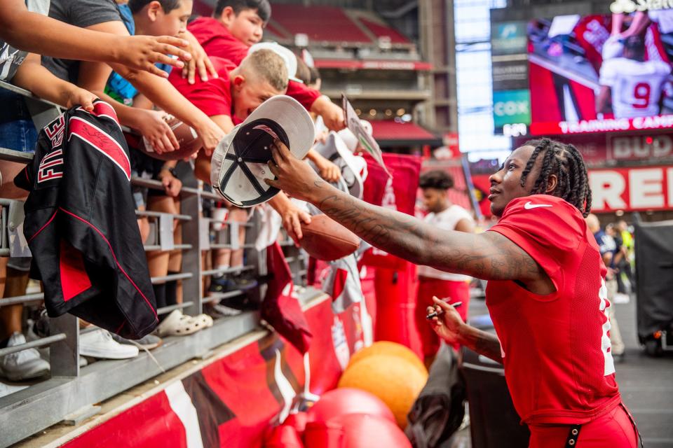 WR Marquise Brown signs a hat after the Arizona Cardinals' annual Red & White practice at State Farm Stadium in Glendale on Aug. 5, 2023.