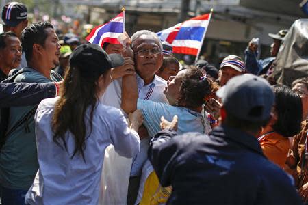 Protest leader Suthep Thaugsuban (C) is hugged by an anti-government protester, as he leads a march through central Bangkok January 30, 2014. REUTERS/Athit Perawongmetha