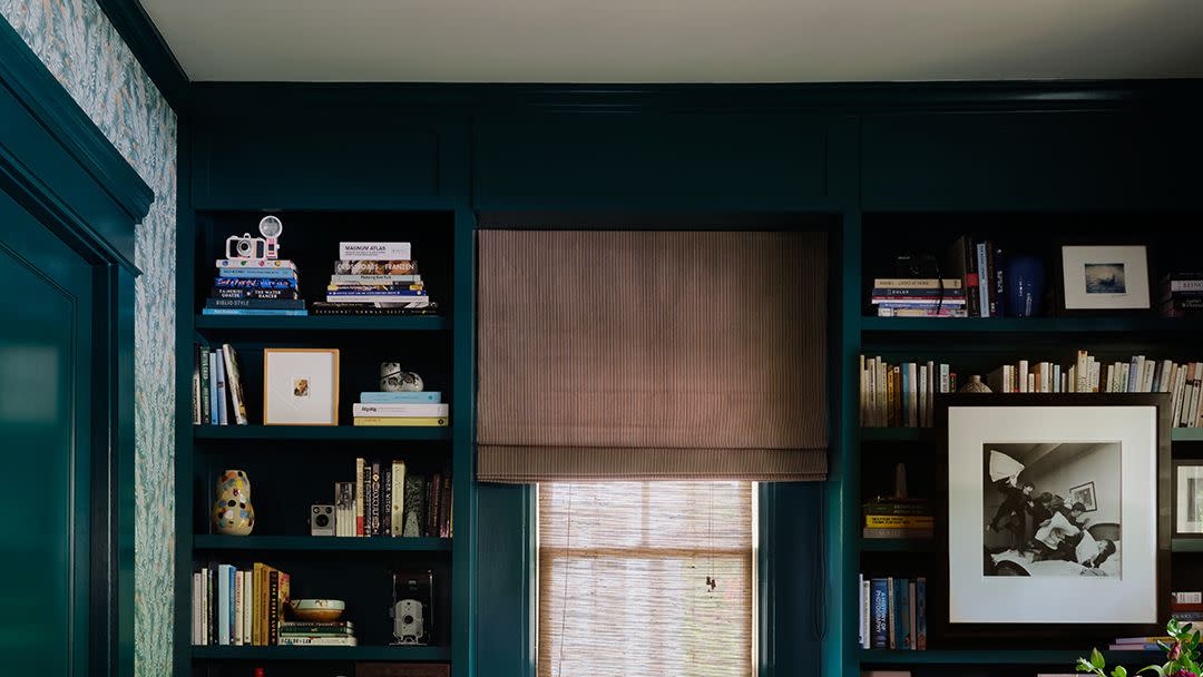 a room with a green couch and bookshelves