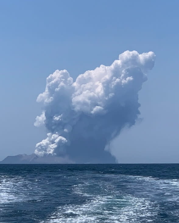 The White Island volcano shown erupting from a distance. Source: AAP