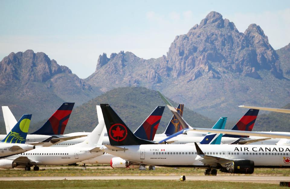 Three Delta Air Lines passenger jets are parked among other airliners at the Pinal Airpark on Tuesday, March 17, 2020, in Marana, Ariz. Because of the coronavirus outbreak, Delta wide-body aircraft are being moved to storage in Arizona.